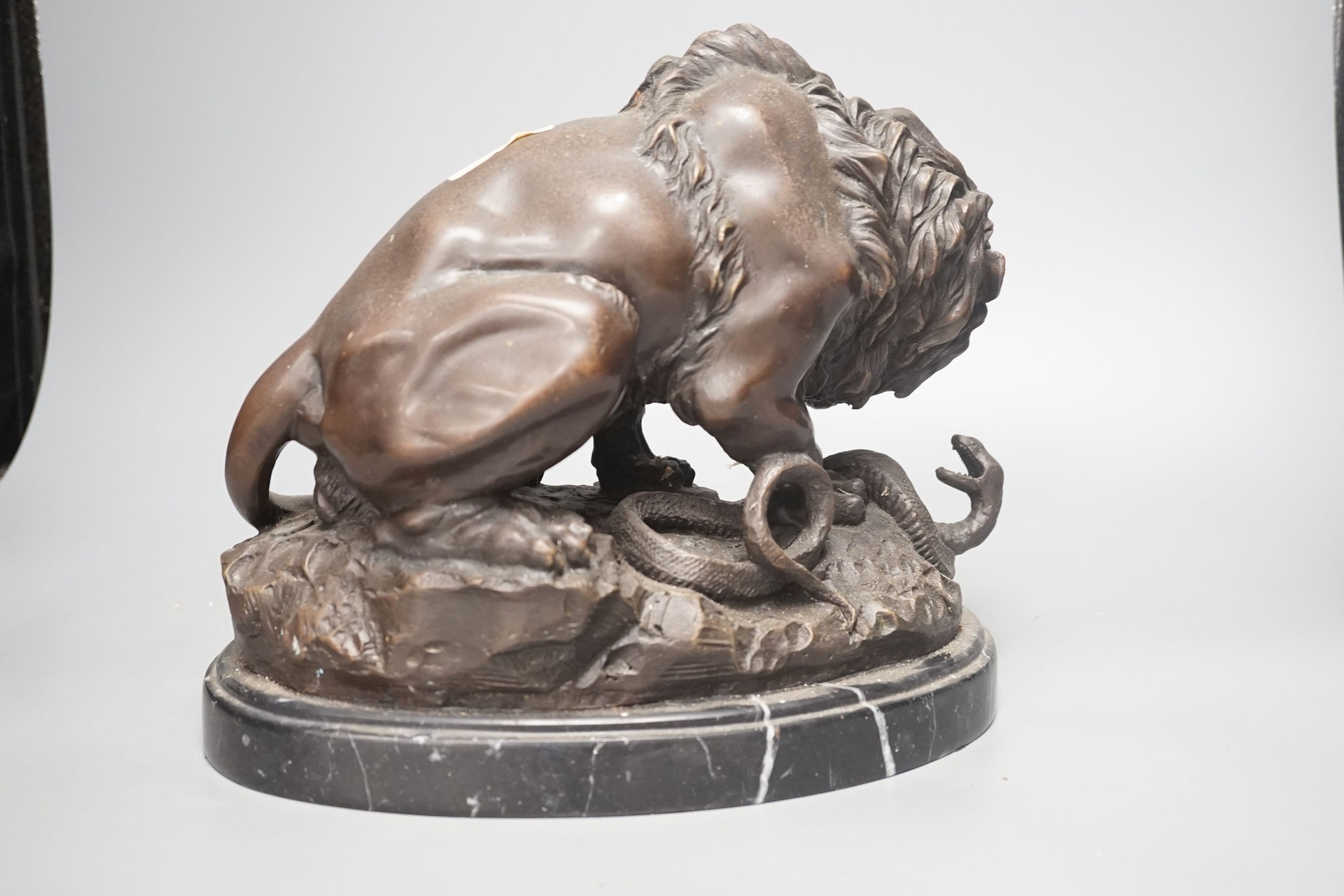 After Barye, a bronzed metal lion and serpent group, 25 cms high.